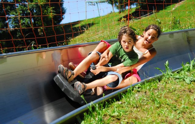 Zwei Kinder fahren auf der Sommerrodelbahn in Laterns und haben Spaß. Zwei Kinder fahren auf der Sommerrodelbahn in Laterns und haben Spaß.